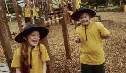 Two school children in the playground laughing