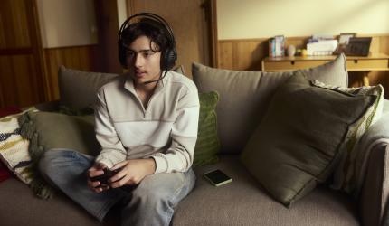 Person sitting on lounge with headphones on